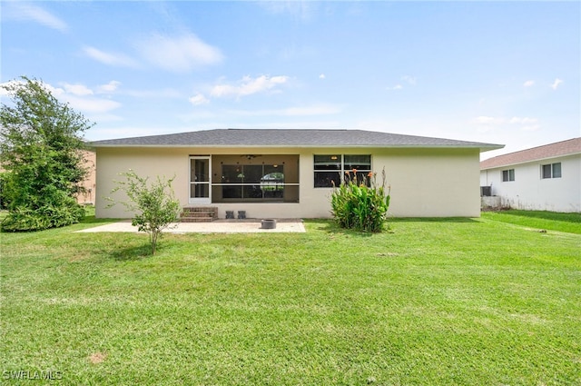 back of property with a sunroom, a yard, and a patio