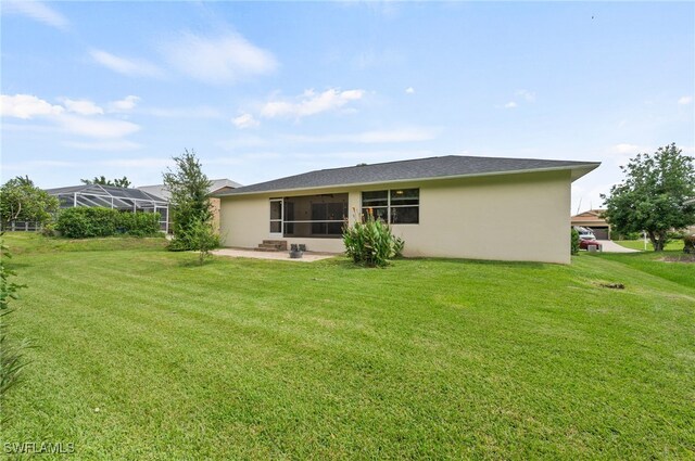 back of property with a yard and glass enclosure