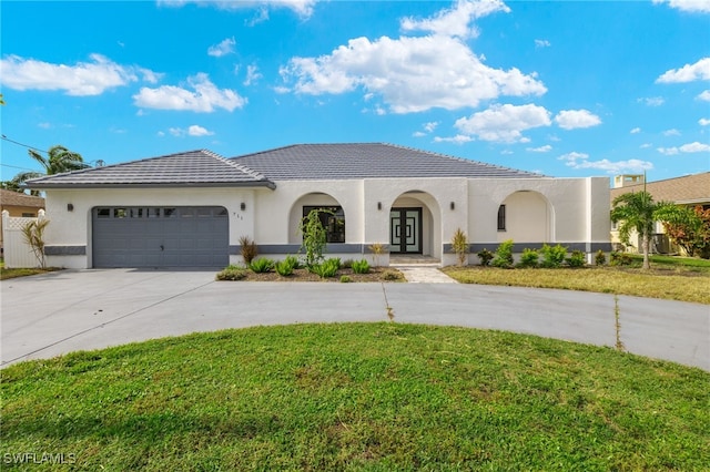 mediterranean / spanish house featuring a front yard and a garage