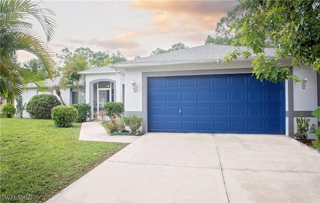 ranch-style house featuring a garage and a lawn