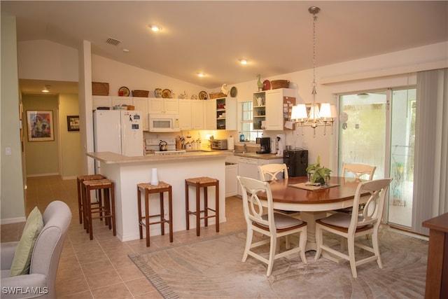 tiled dining area featuring vaulted ceiling, sink, and a chandelier