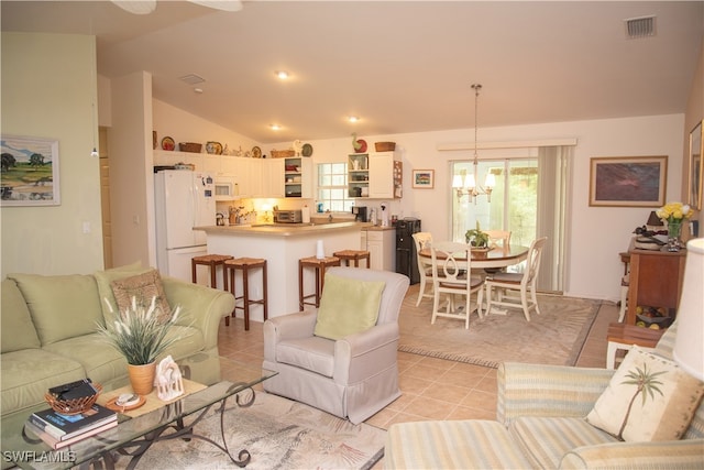 tiled living room with a chandelier and vaulted ceiling