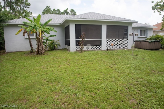 rear view of house with a sunroom and a lawn