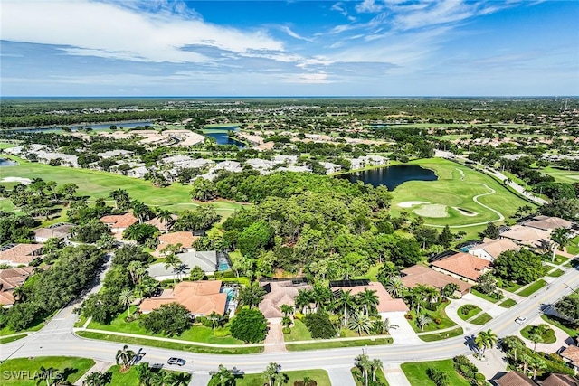 drone / aerial view with view of golf course, a water view, and a residential view