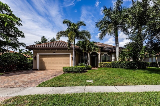 mediterranean / spanish-style home with a garage and a front lawn