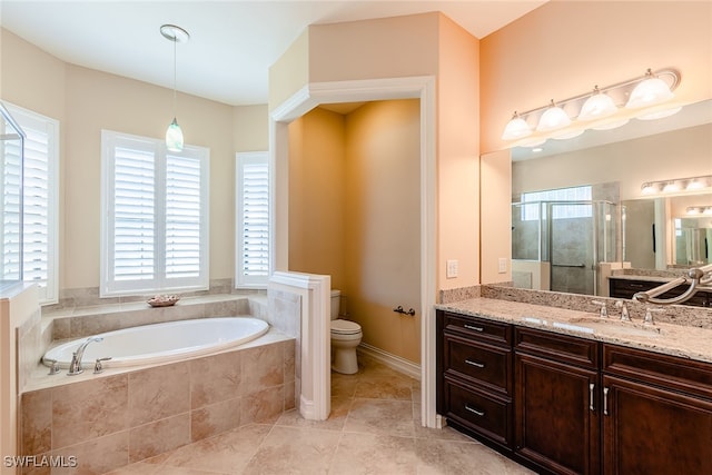 bathroom with a relaxing tiled tub, toilet, vanity, and tile patterned floors