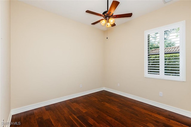 empty room with wood finished floors, a ceiling fan, and baseboards