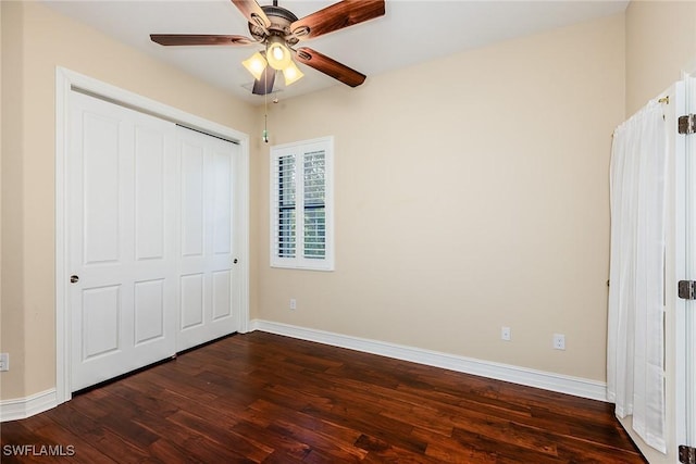 unfurnished bedroom with dark wood-style floors, ceiling fan, baseboards, and a closet