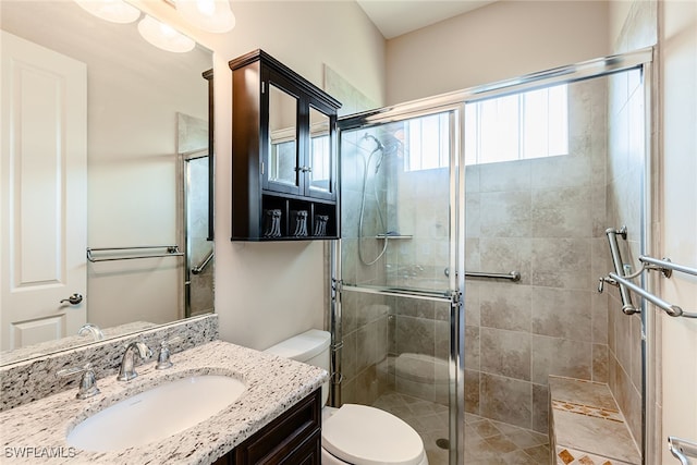 bathroom with a shower with shower door, toilet, and vanity