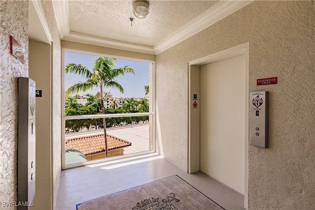 doorway to outside featuring a textured ceiling, crown molding, and elevator