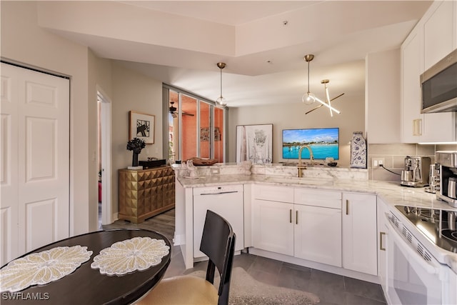 kitchen featuring white cabinetry, light stone counters, white dishwasher, sink, and kitchen peninsula