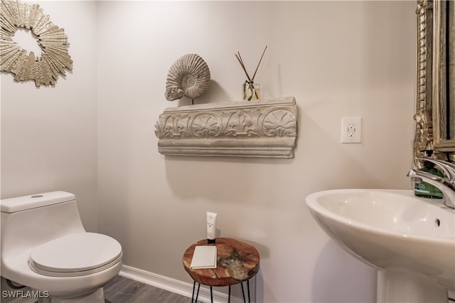 bathroom with sink, wood-type flooring, and toilet