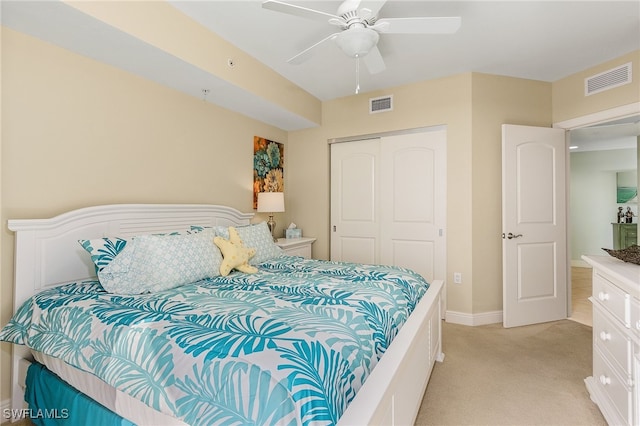 bedroom featuring ceiling fan, a closet, and light colored carpet