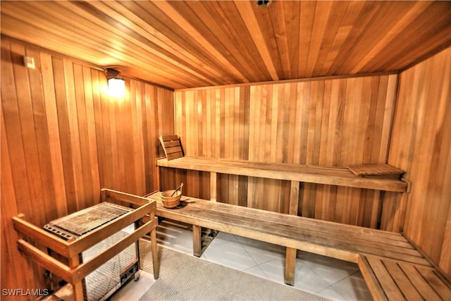 view of sauna featuring wooden ceiling, wood walls, and tile patterned floors