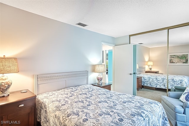 carpeted bedroom with a closet and a textured ceiling