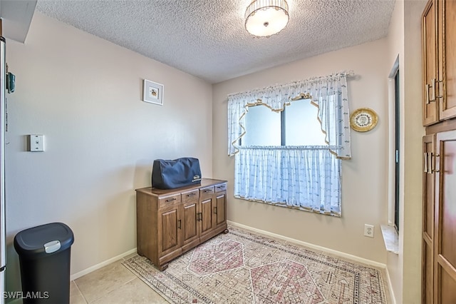 interior space featuring light tile patterned floors and a textured ceiling