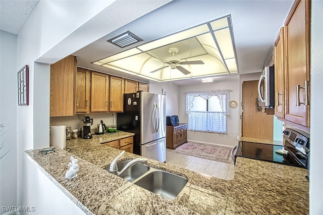 kitchen featuring sink, ceiling fan, light tile patterned floors, kitchen peninsula, and stainless steel appliances