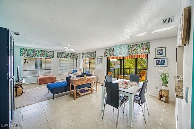 dining area with ceiling fan, light tile patterned floors, and a textured ceiling