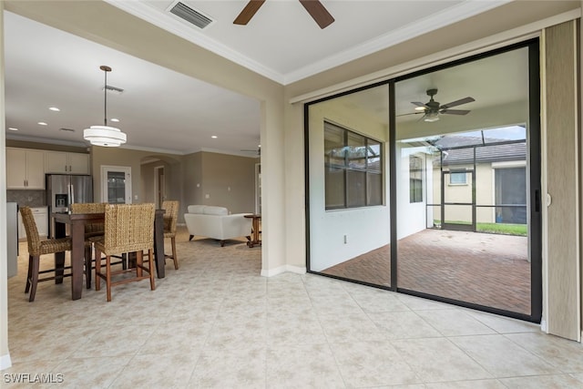 interior space with ceiling fan and crown molding