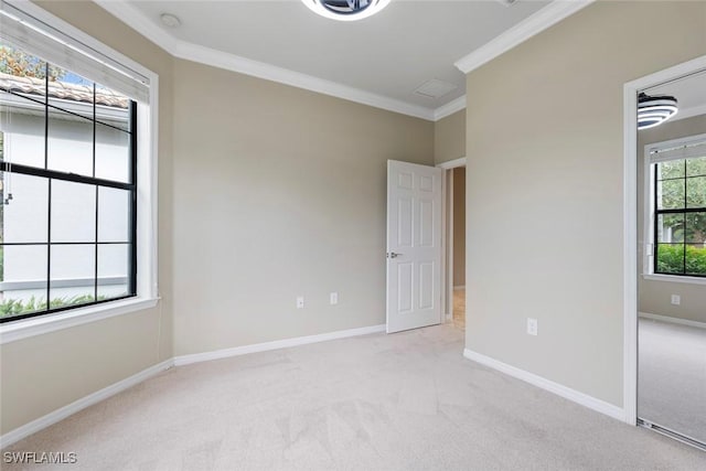 carpeted empty room featuring a healthy amount of sunlight and crown molding