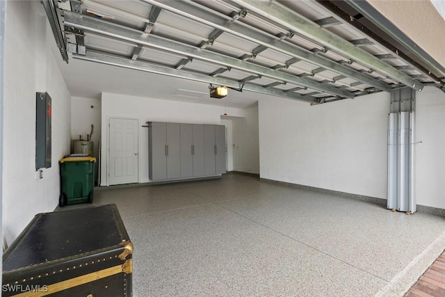 garage featuring electric panel, electric water heater, and a garage door opener