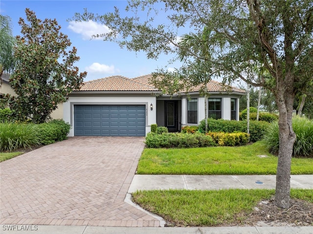 mediterranean / spanish house featuring a front yard and a garage