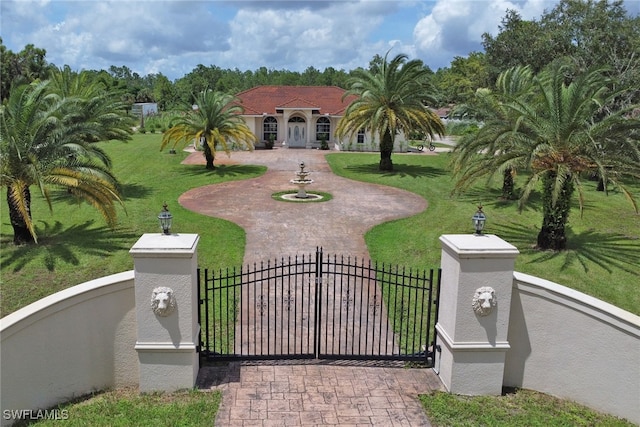 3711 4th Ave SE, Naples, FL 34117 - view of front facade with stucco siding, a gate, and curved driveway