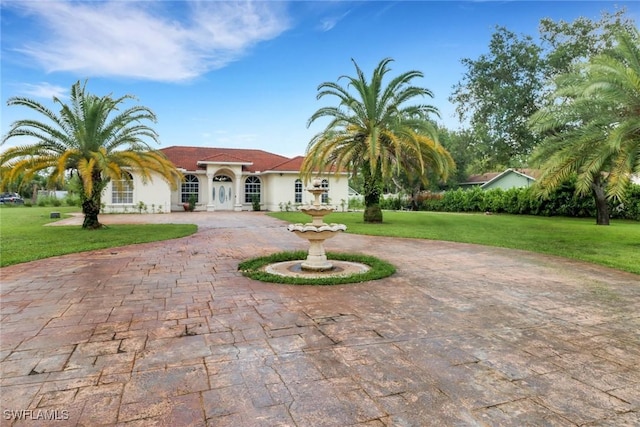 3711 4th Ave SE, Naples, FL 34117 - mediterranean / spanish home with curved driveway, a front yard, and stucco siding