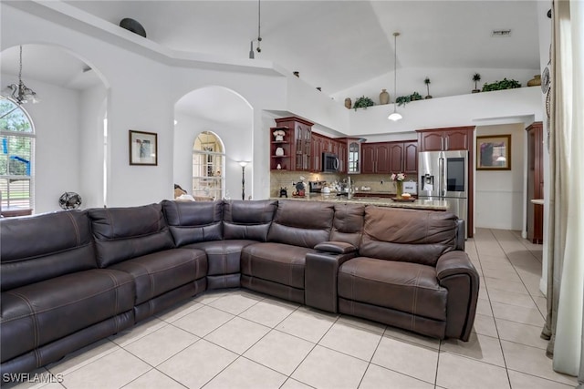 3711 4th Ave SE, Naples, FL 34117 - living room with light tile patterned floors, arched walkways, and lofted ceiling