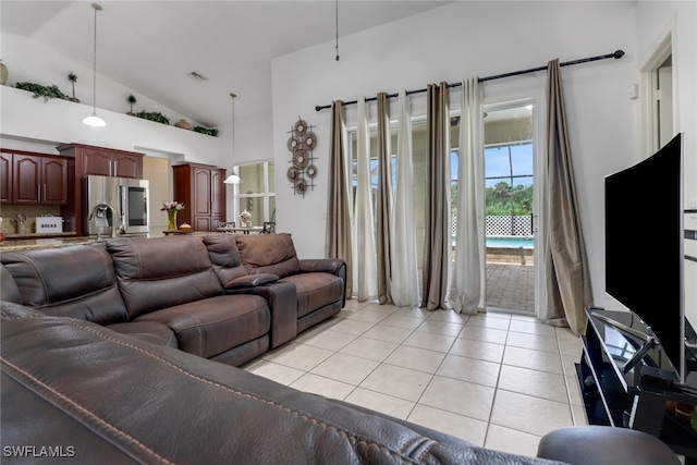 living room with light tile patterned flooring and high vaulted ceiling