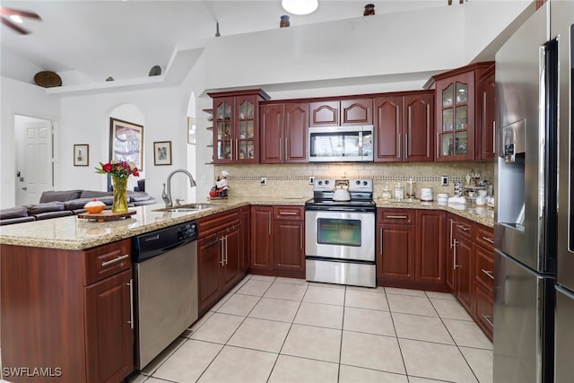 kitchen with sink, stainless steel appliances, kitchen peninsula, and backsplash