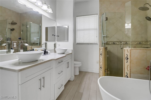 full bathroom featuring double sink vanity, toilet, and independent shower and bath