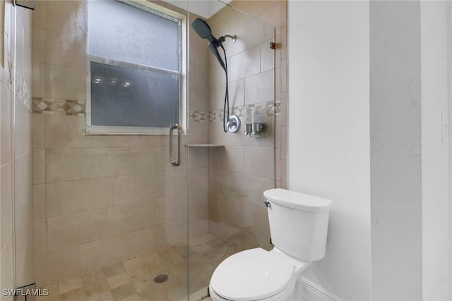 bathroom featuring toilet and an enclosed shower