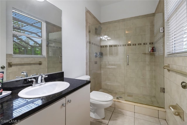 bathroom featuring a shower with door, toilet, tile patterned floors, and vanity