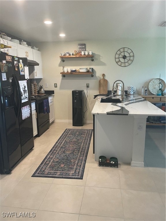 kitchen with white cabinetry, light stone countertops, black fridge with ice dispenser, light tile patterned floors, and range with electric stovetop