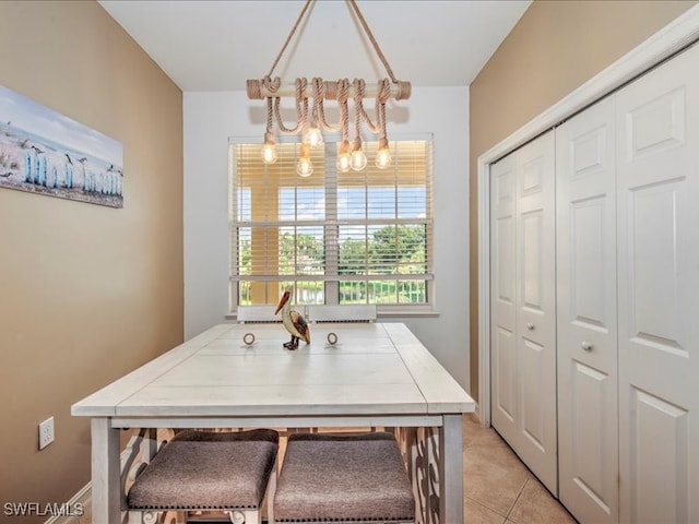 tiled dining room featuring an inviting chandelier