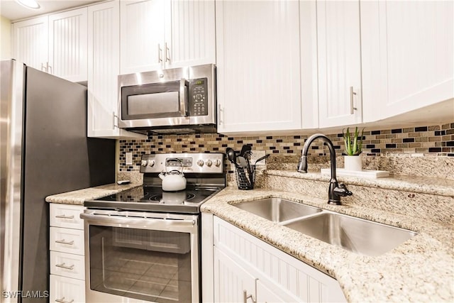 kitchen featuring sink, white cabinetry, stainless steel appliances, and tasteful backsplash