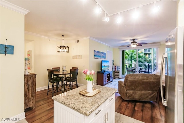 living room with hardwood / wood-style flooring, ceiling fan with notable chandelier, ornamental molding, and rail lighting