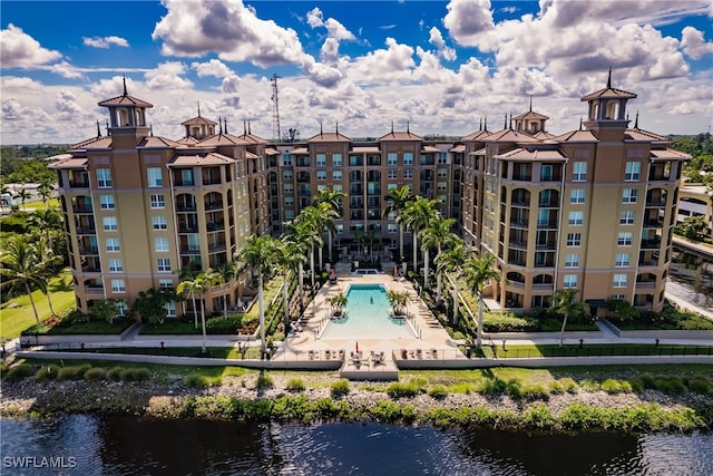 view of property with a community pool and a water view