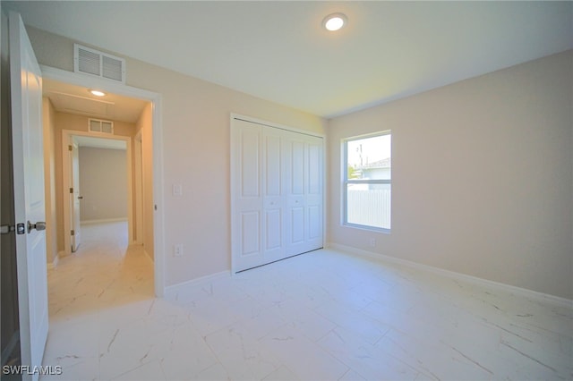 unfurnished bedroom featuring a closet and light tile patterned floors