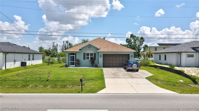 view of front of home featuring a front lawn, central AC unit, and a garage