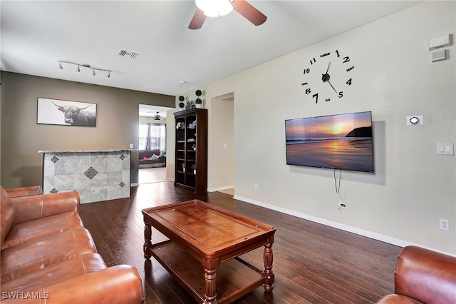 living room with ceiling fan, track lighting, and dark hardwood / wood-style flooring