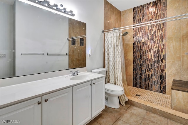 bathroom with a shower with curtain, tile patterned floors, vanity, and toilet