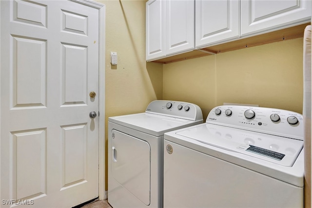 laundry area featuring washing machine and dryer and cabinets