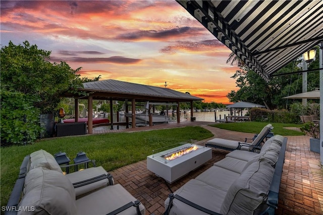 patio terrace at dusk with a gazebo and an outdoor living space with a fire pit