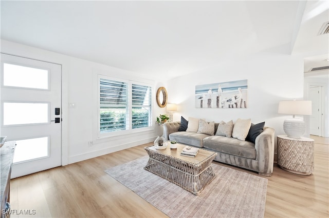 living room featuring vaulted ceiling and light wood-type flooring