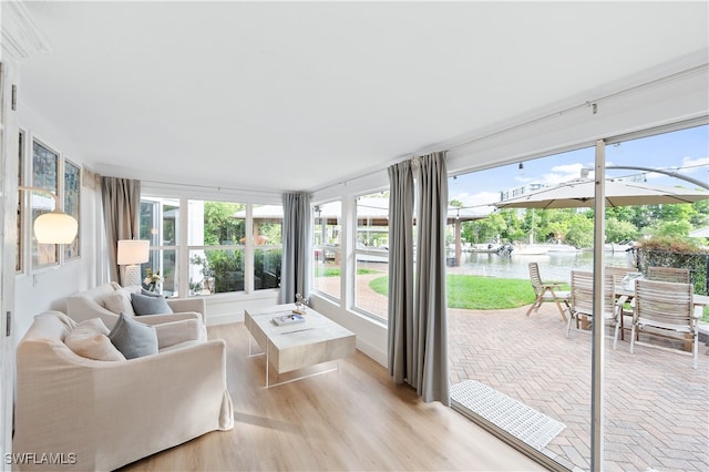 sunroom / solarium with a water view and plenty of natural light