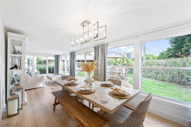 sunroom / solarium featuring an inviting chandelier