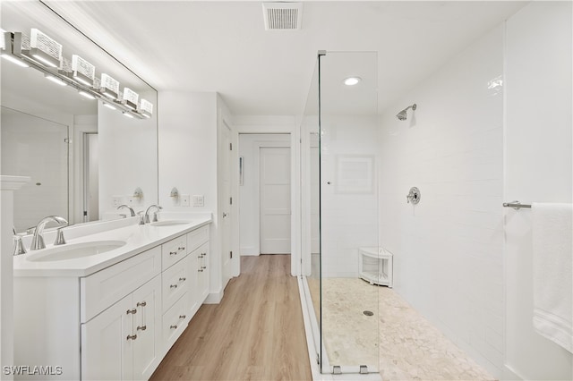 bathroom featuring hardwood / wood-style flooring, vanity, and a shower