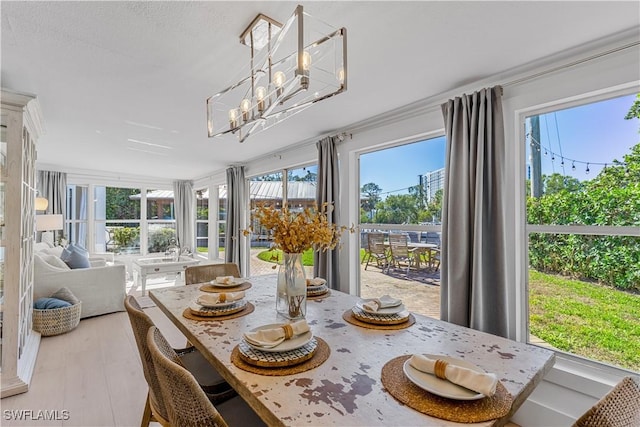 dining room with a notable chandelier, light hardwood / wood-style flooring, and ornamental molding